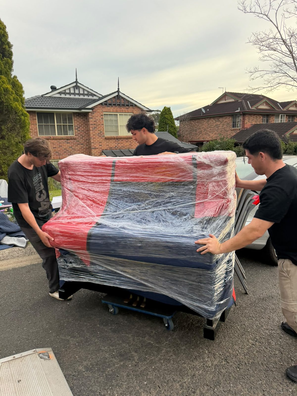 Team of 3 lifting wrapped sofa